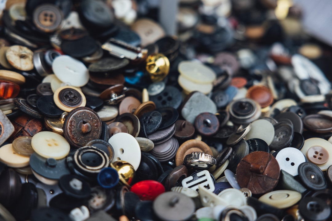 A large pile of assorted buttons in various shapes, sizes, and colors, closely packed together—perfect accents for bespoke suits and the best bespoke tailoring.