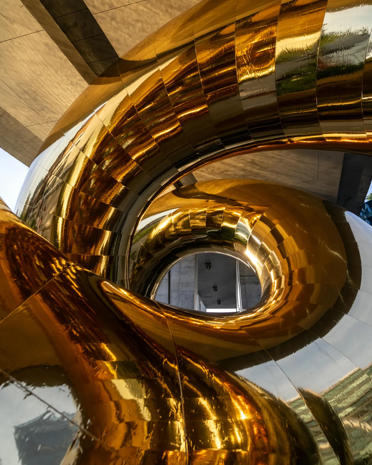 Close-up of the golden, mirror-polished coils of the Bulgari Serpenti installation