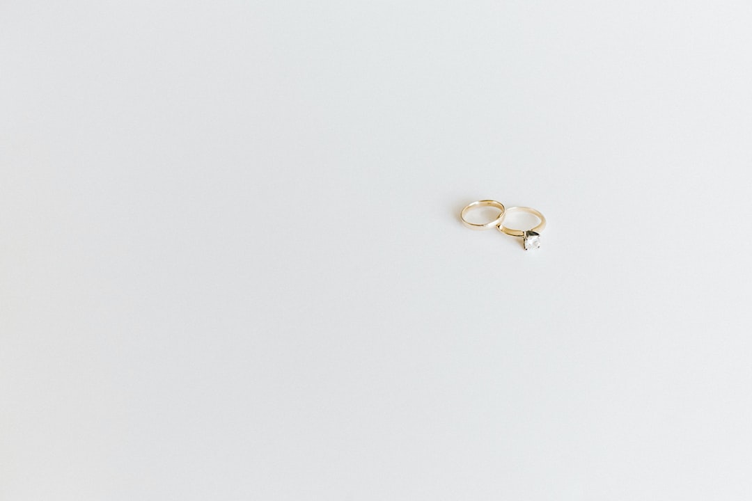 Two gold rings, one with a large diamond, rest on a plain white surface, showcasing the timeless elegance of modern jewelry inspired by Bvlgari’s Roman roots.