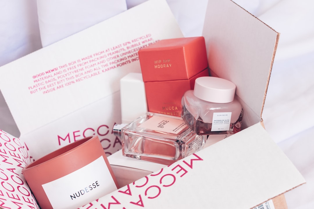 A box containing Mecca beauty products, including a candle, perfume, skincare jar, and packaged items—all arranged on white tissue paper—showcasing Ethical Beauty and a commitment to Cruelty-Free Kosmetik.