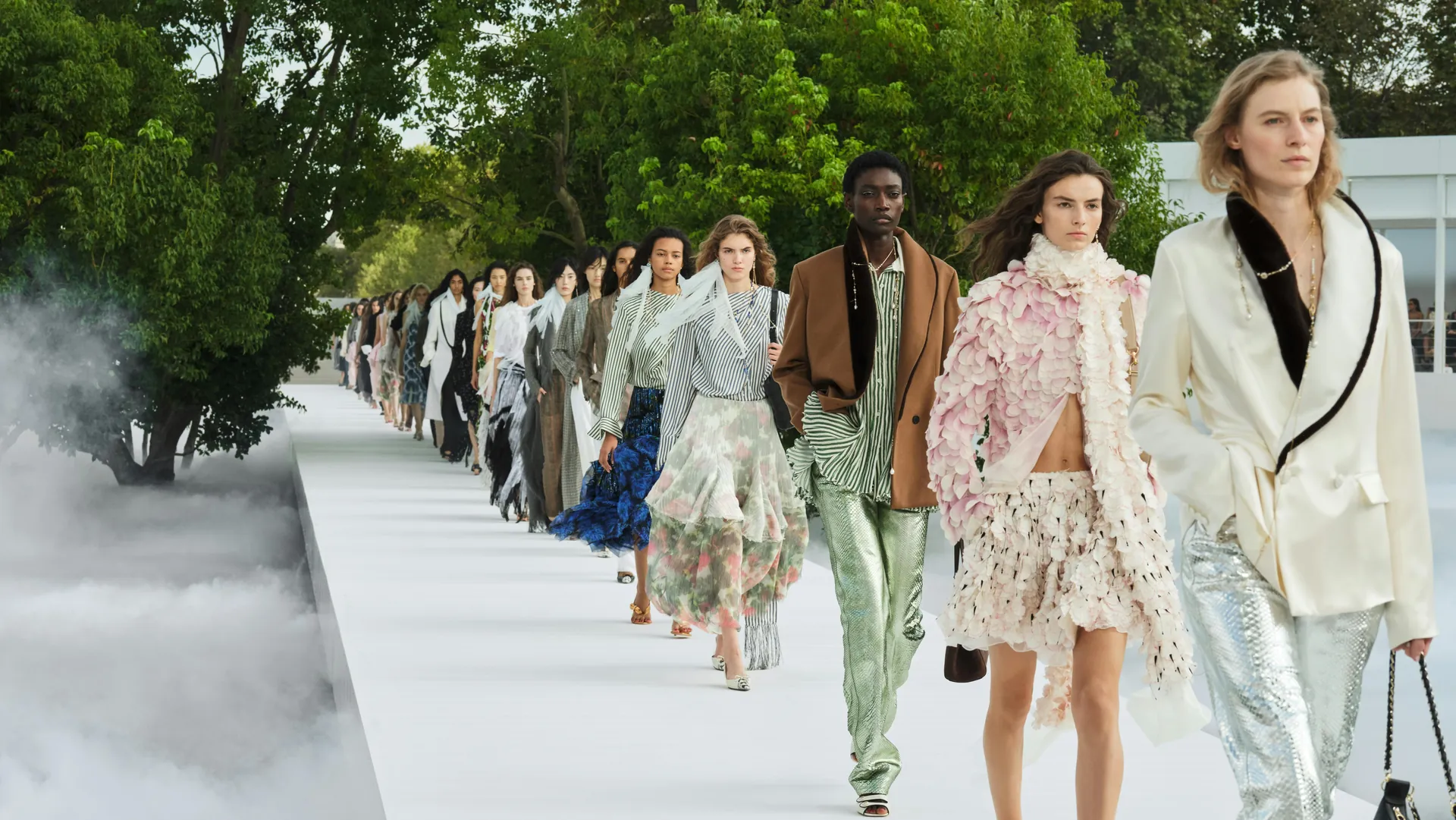 Finale of the Dior Summer 2027 women's show: models on a white runway lined with trees and mist