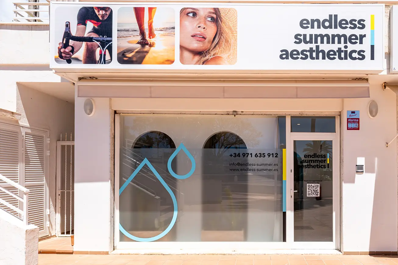 The storefront of Endless Summer Aesthetics features a large luxury sign, images of a cyclist and a woman, and the clinic’s contact information on the glass door and window.