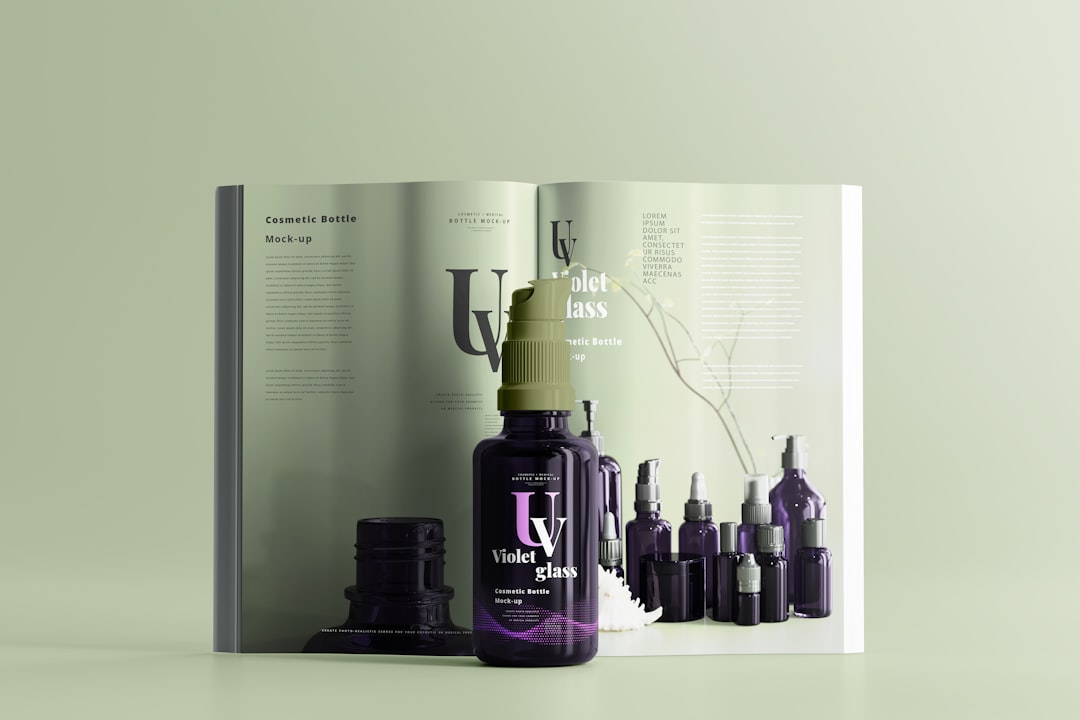 A dark violet glass cosmetic bottle with a dropper cap, perfect for essential oils or skin care benefits, is placed in front of an open magazine displaying similar bottles and product information.