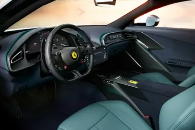 The interior of a modern Ferrari car exudes luxury, featuring a leather-wrapped steering wheel with logo, digital dashboard, touchscreen, and striking green leather seats.