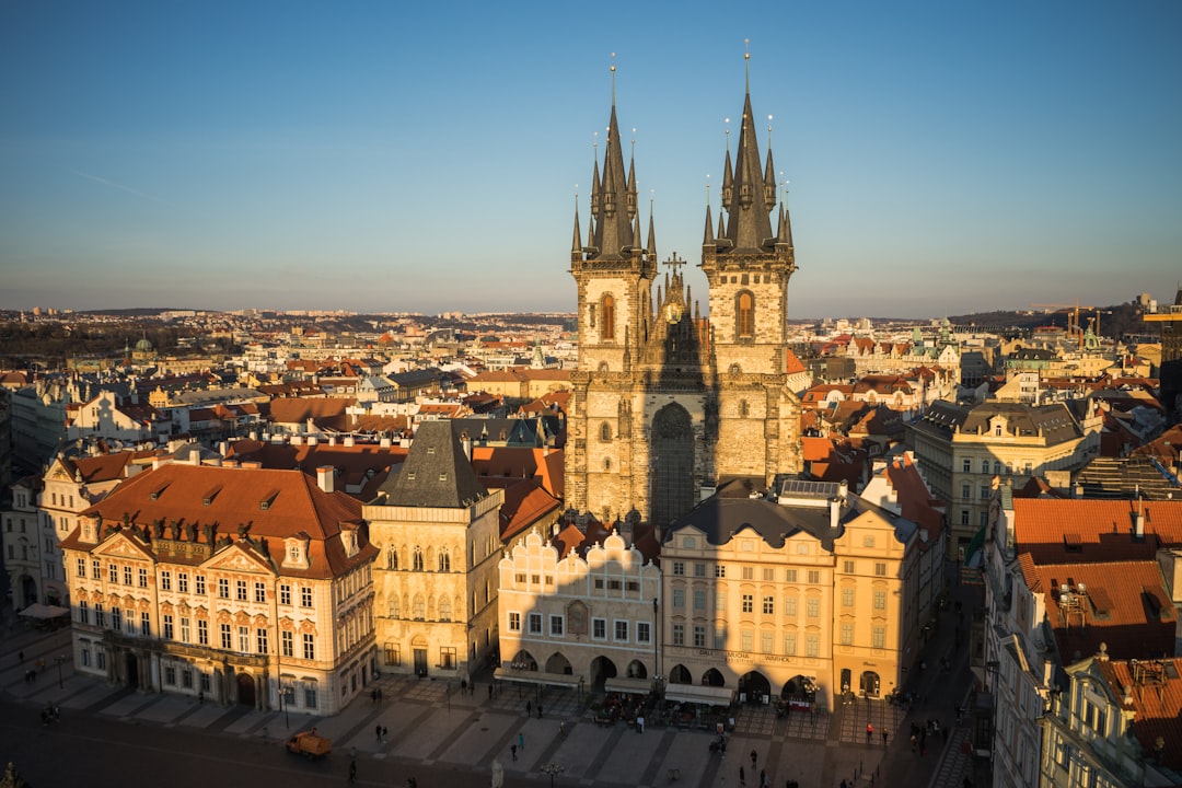 Aerial view of Old Town Square in Prague with the Church of Our Lady before Týn, historic buildings, and a clear sunset sky—perfect for a memorable city break or luxurious urban escapes.
