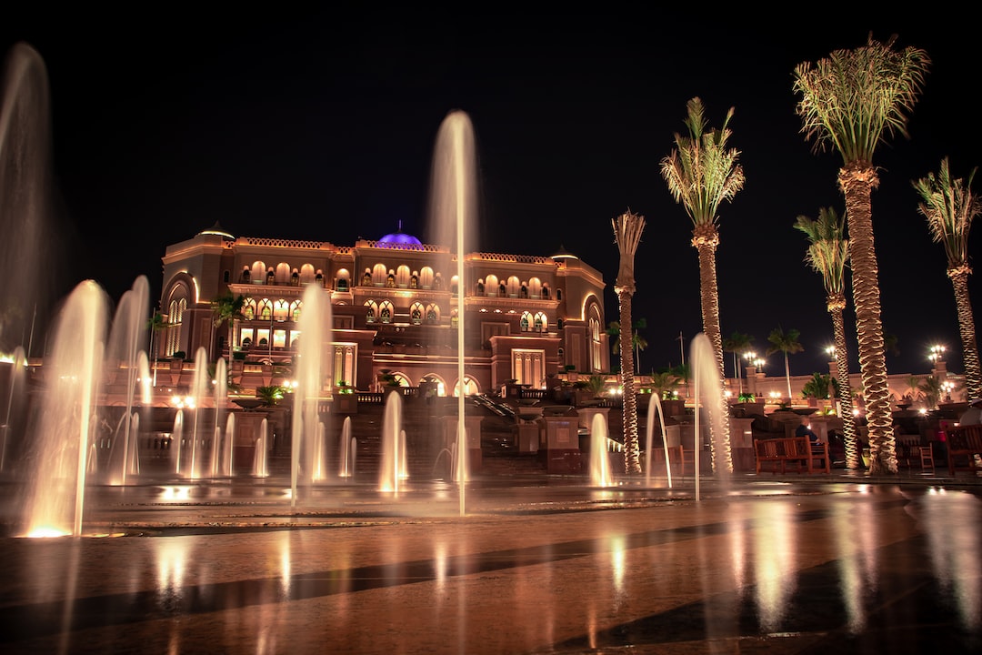 Night view of an ornate hotel building with illuminated arches, palm trees, and fountains in the foreground—a stunning destination for travelers exploring the world’s most expensive cities.