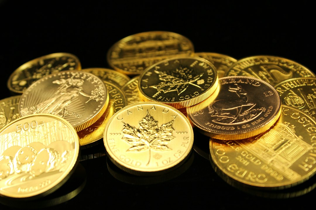 A collection of various gold coins from different countries displayed on a black surface, showcasing the beauty and value of these timeless pieces.