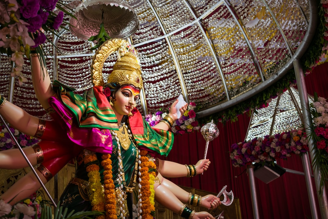 Large statue of Hindu goddess Durga adorned with jewelry, colorful clothes, and garlands, crafted with intricate detail and displayed under a decorated canopy, reminiscent of the exquisite craft seen in Tokyo’s luxury watchmaking.