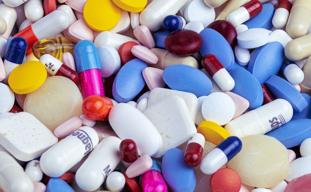 A large assortment of various colored pills, capsules, and tablets in different shapes and sizes scattered together, featuring luxury vitamin supplements and bespoke vitamin supplements for a tailored wellness experience.