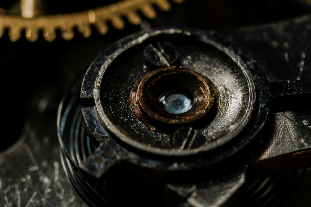 Close-up view of an intricate mechanical watch part, showcasing metal gears and a central screw with detailed textures—echoing the timeless beauty often found in antique jewelry.