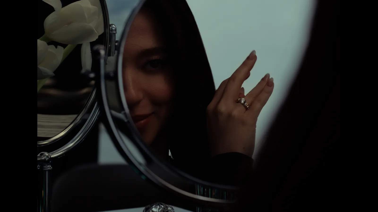 Tiffany & Co. campaign film still: Mikey Madison reflected in a mirror, the Sixteen Stone by Tiffany ring on her hand