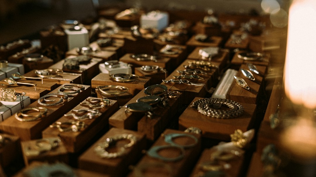 A display of handcrafted gold and silver jewelry pieces, including rings, bracelets, and earrings, arranged on wooden stands exudes timeless elegance.