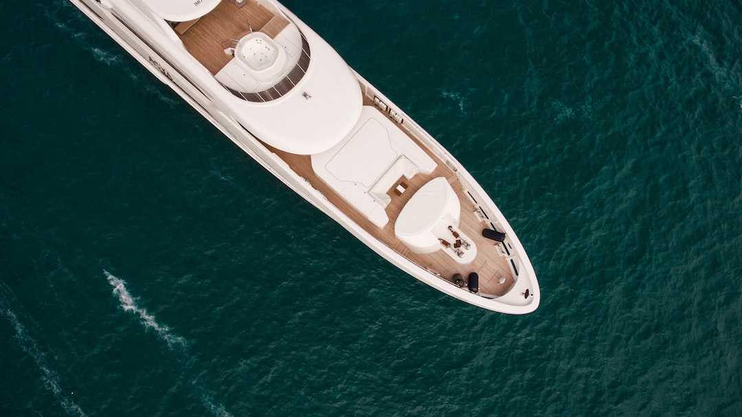 Aerial view of a white luxury yacht cruising on deep blue ocean water, embodying the ultimate Miami Yacht Life.